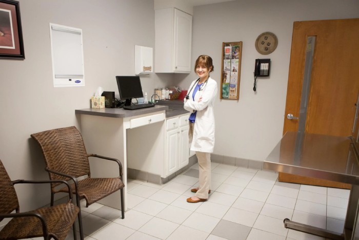 A veterinarian standing inside hospital room